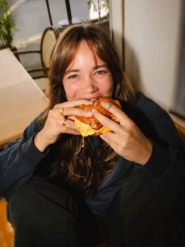 A guest enjoying a burger at Benny and Brew
