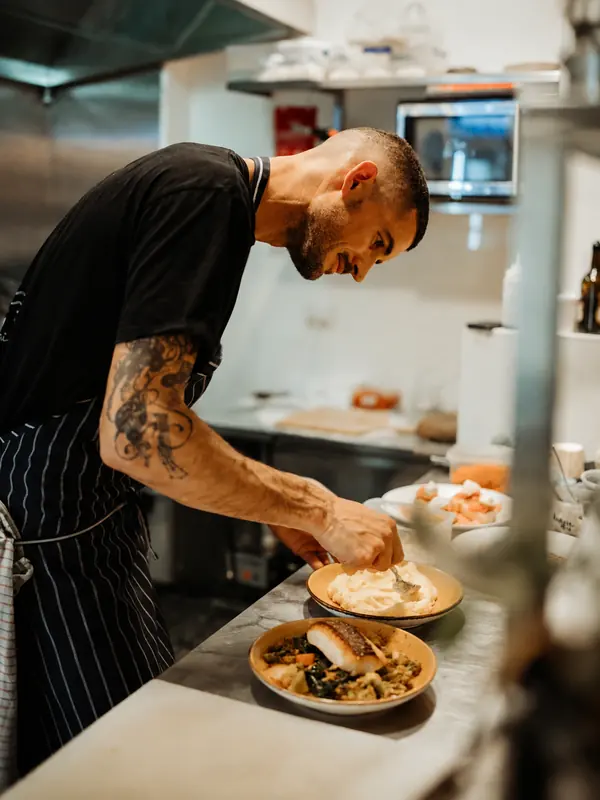 Chef plating dishes in the Benny and Brew kitchen